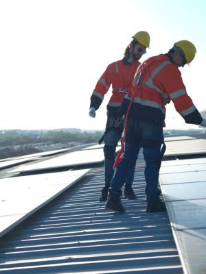 Engineer and technician working on the solar panel on the warehouse roof to inspect the solar panels that have been in operation for some time.